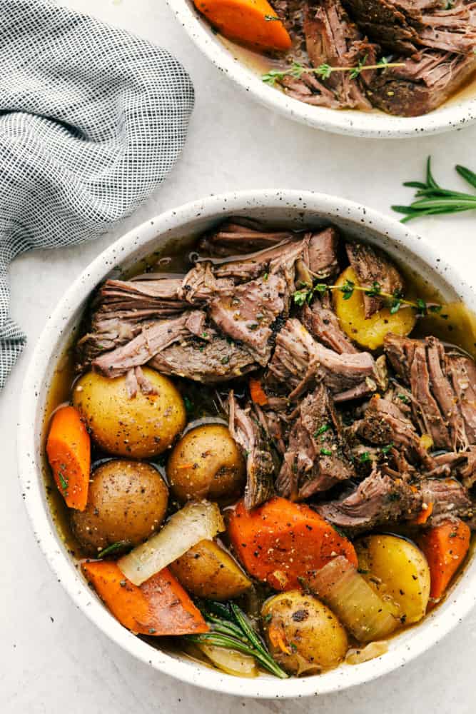 Shredded roast and vegetables served in a white bowl.
