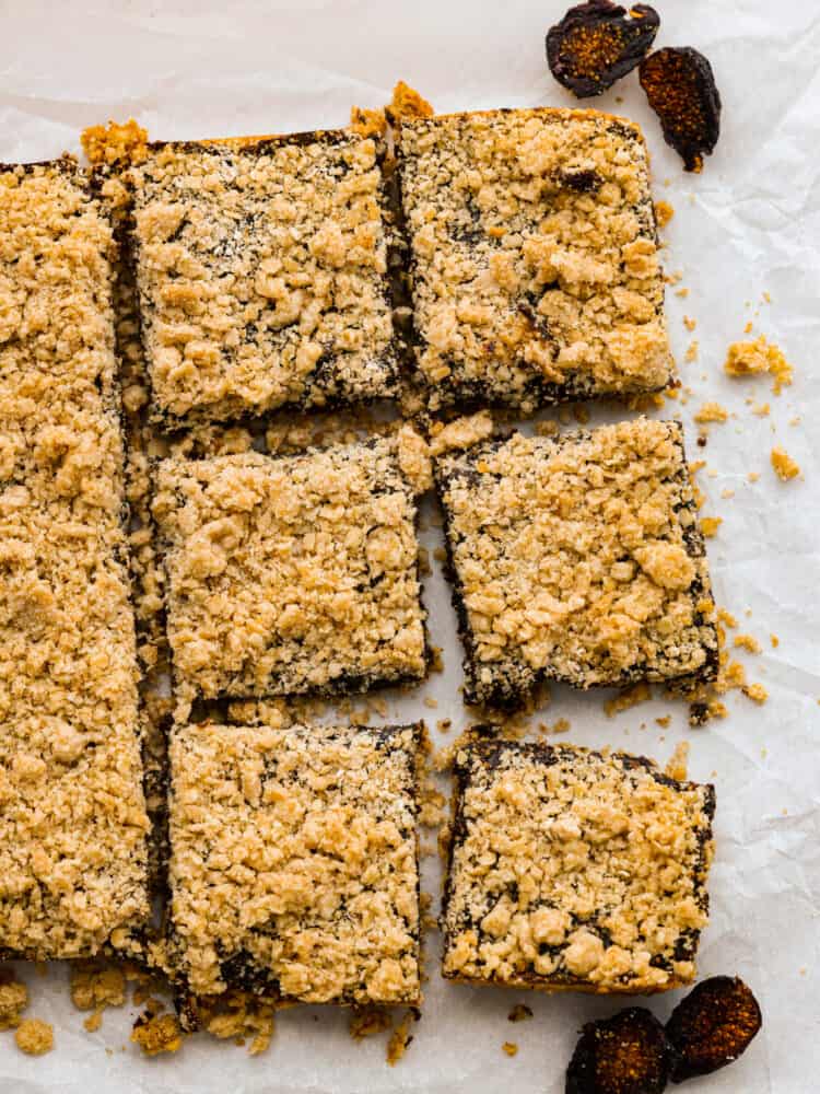 Oatmeal fig bars lined up on parchment paper and cut into squares.