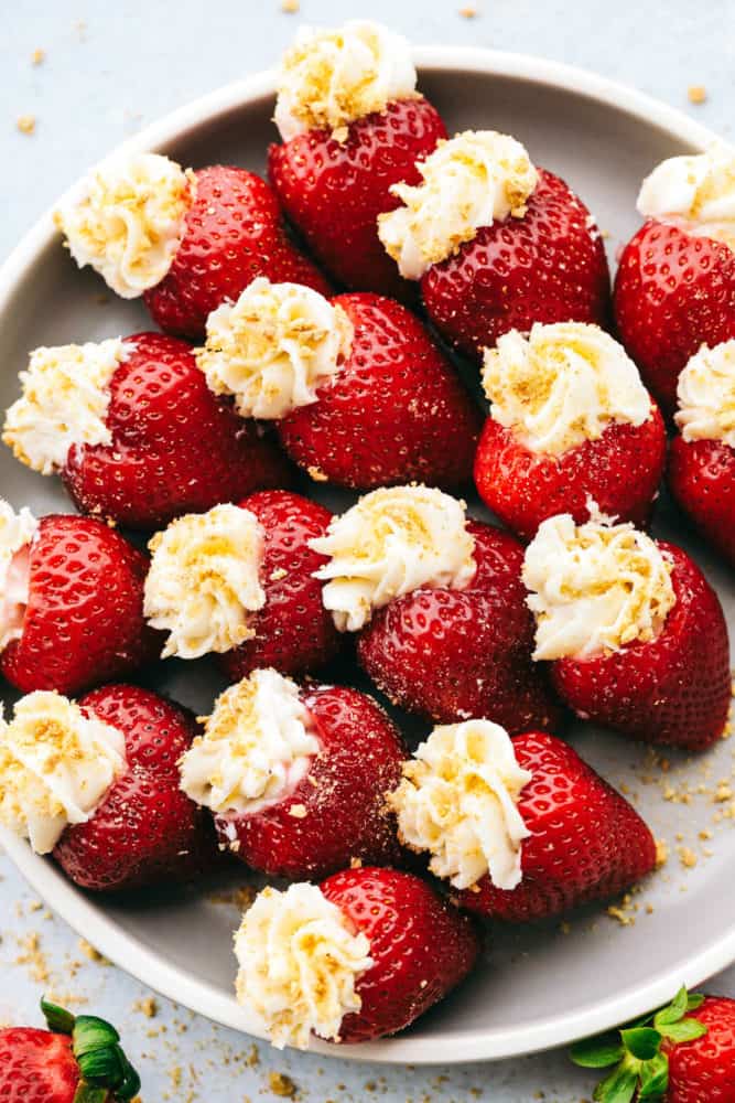 A plate filled with cheesecake stuffed strawberries.