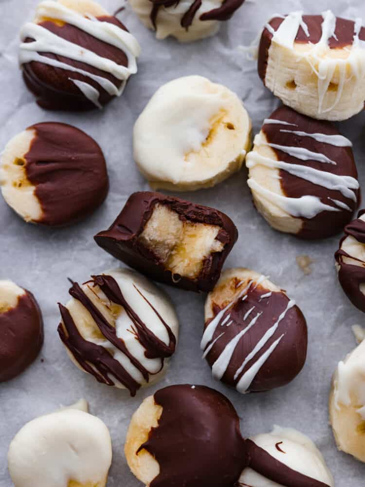 Hero image of chocolate covered banana slices on parchment paper.