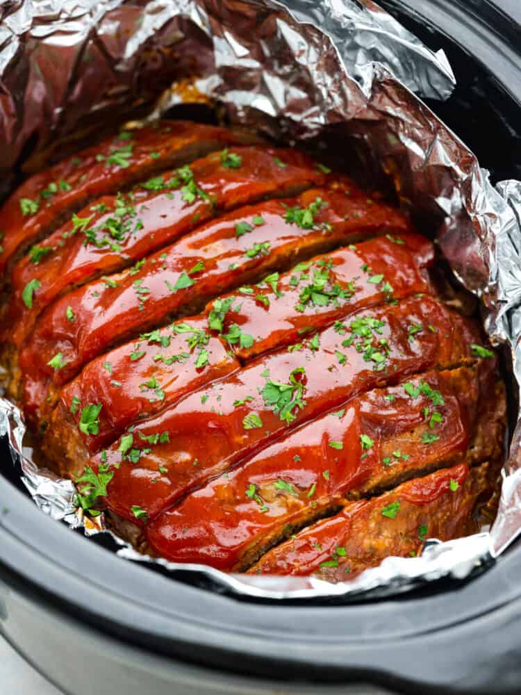 Meatloaf in a crockpot, cut into slices.