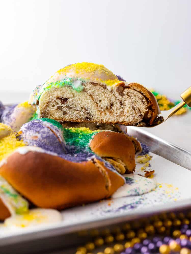 A slice of king cake being served with a spatula.