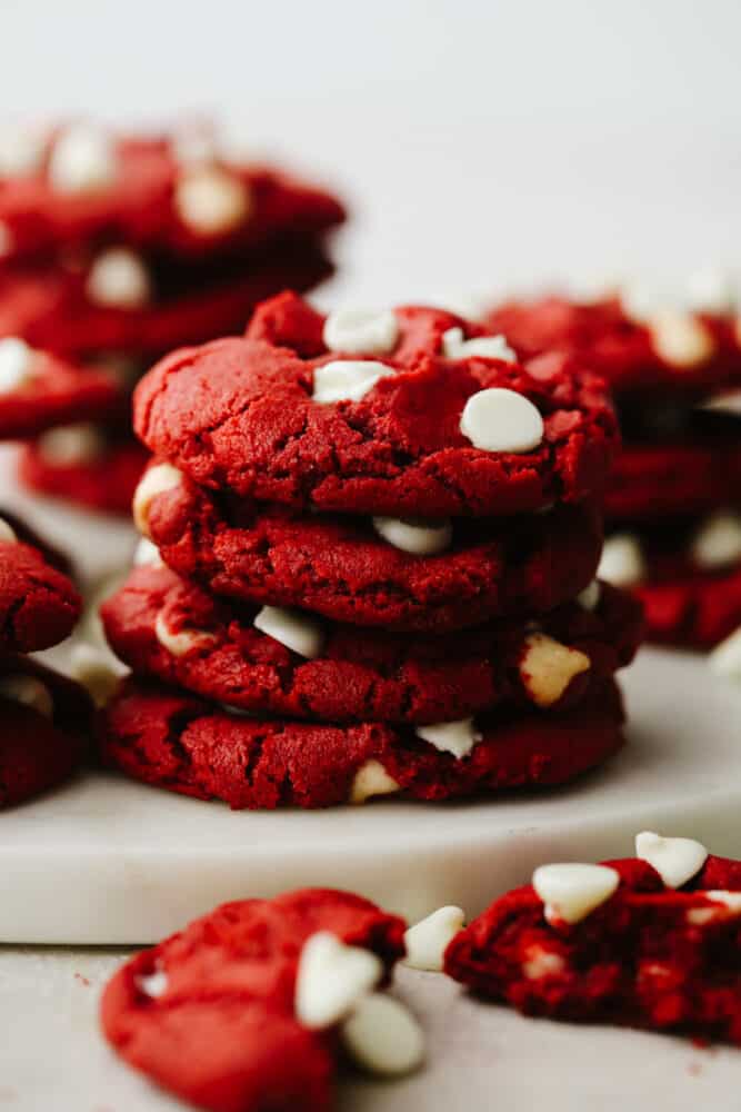 Red velvet cookies with white chocolate chips stacked on top of each other.