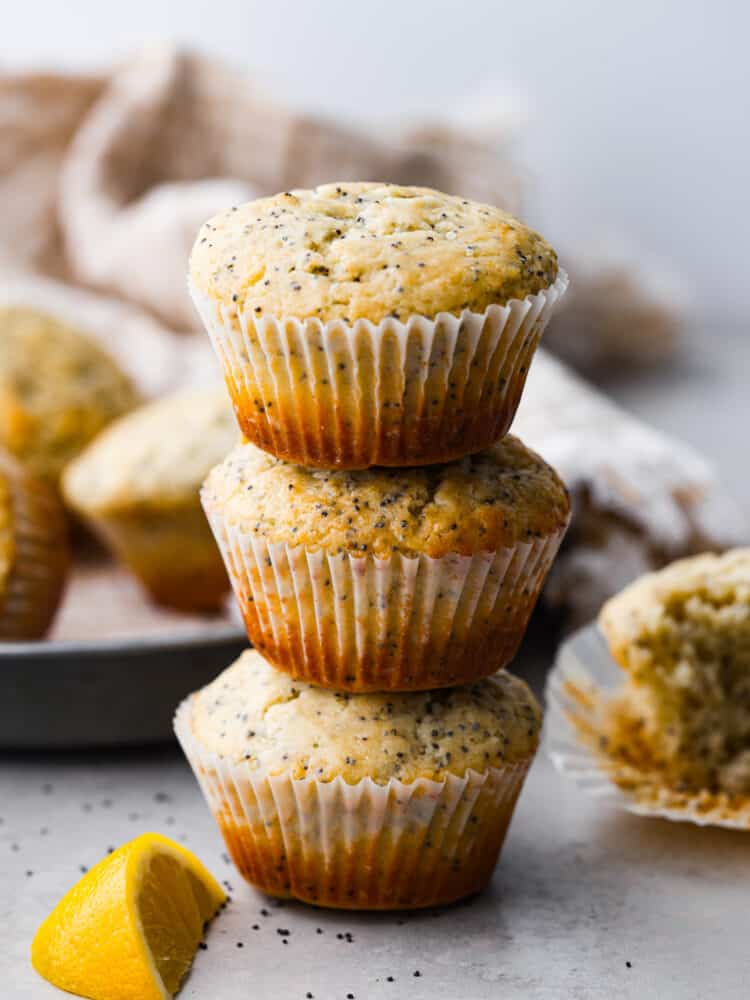 3 lemon poppy seed muffins stacked on top of each other.