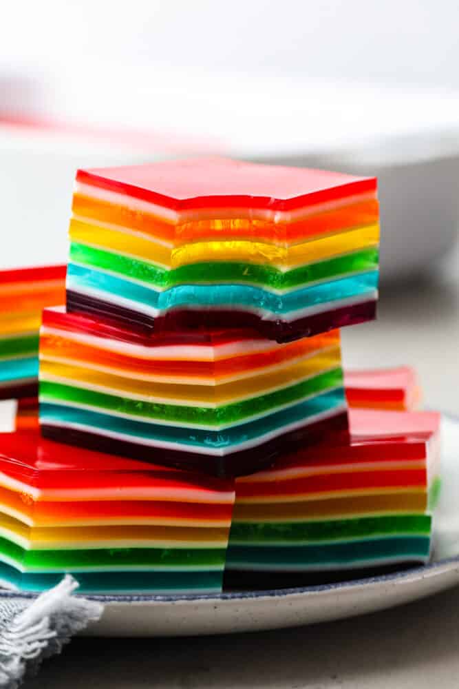 Jello squares stacked on top of each other, one has a bite taken out of it.