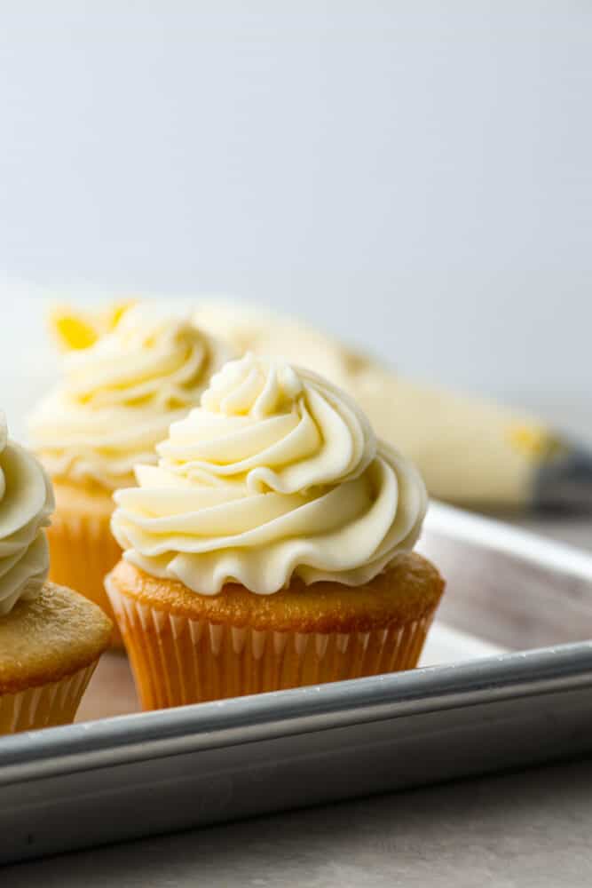 Hero image of a yellow cake cupcake frosted with buttercream.