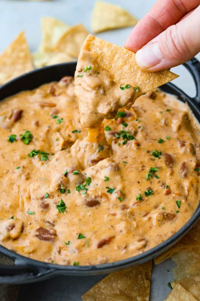 Hero image of a chip being dipped into chili cheese dip.
