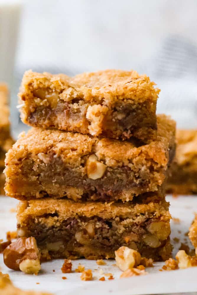 A close up on brown butter blondies stacked on top of each other.