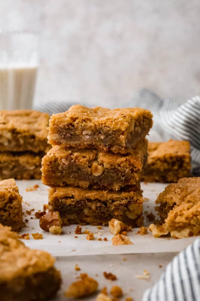 Brown butter blondies stacked on top of each other on a plate.