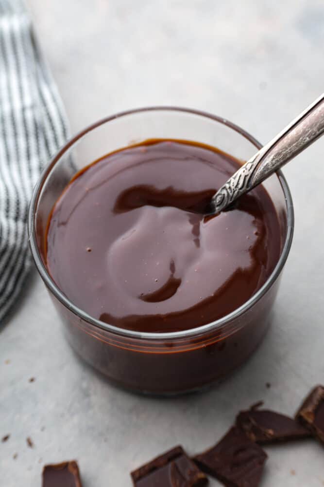 An overhead view of chocolate ganache in a glass container.