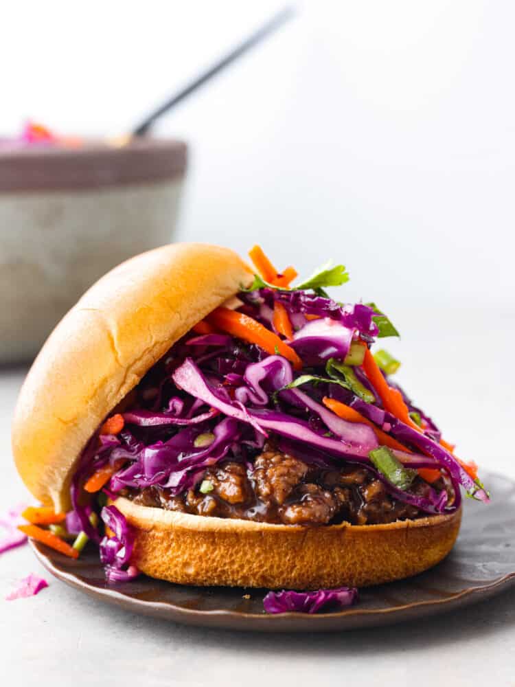 Red cabbage slaw served on a sandwich.