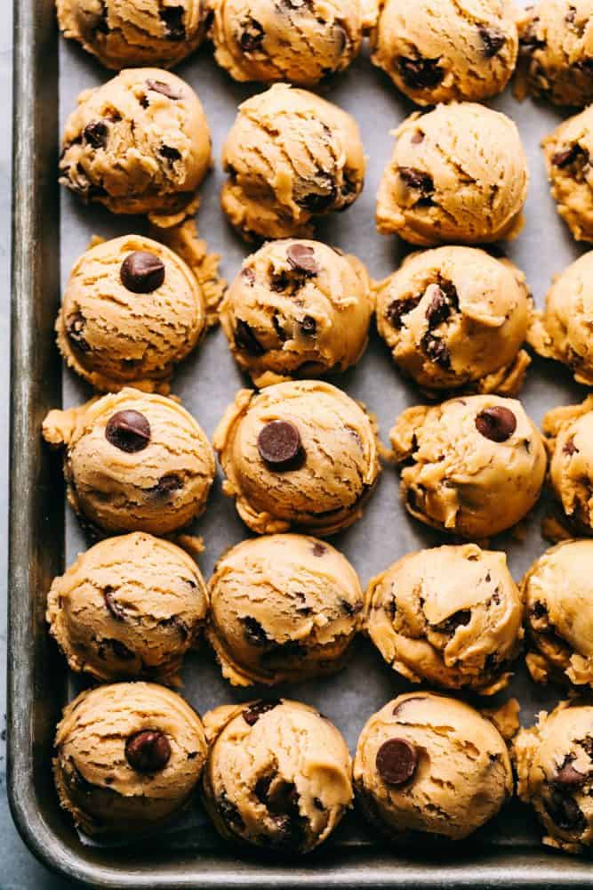 Cookie dough in rows on a baking sheet.