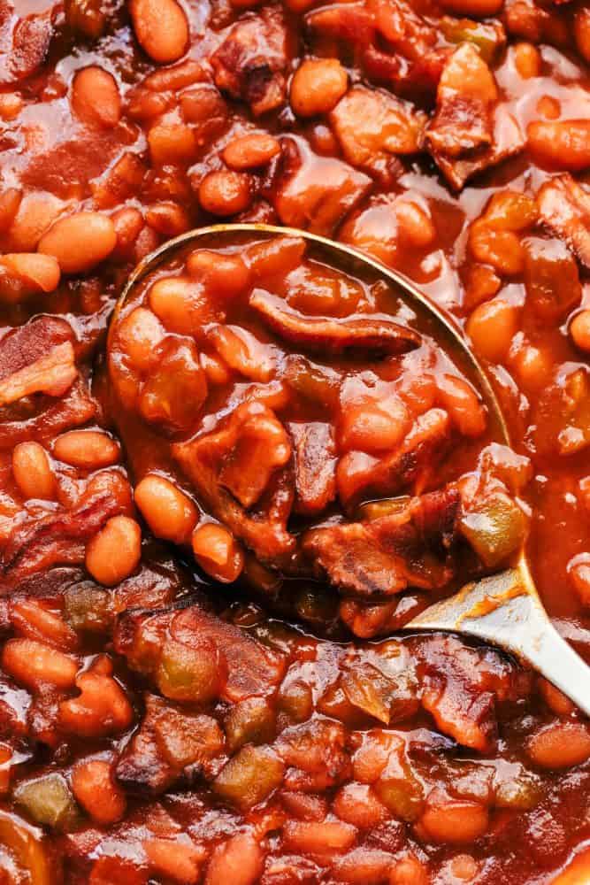 Close-up of baked beans with a metal spoon. 