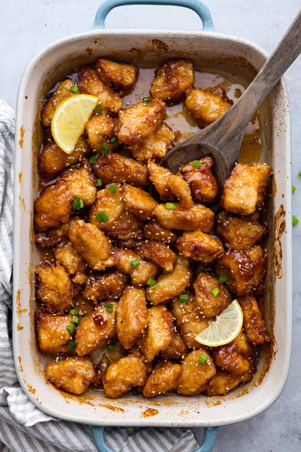Chinese lemon chicken in a blue and white casserole dish.