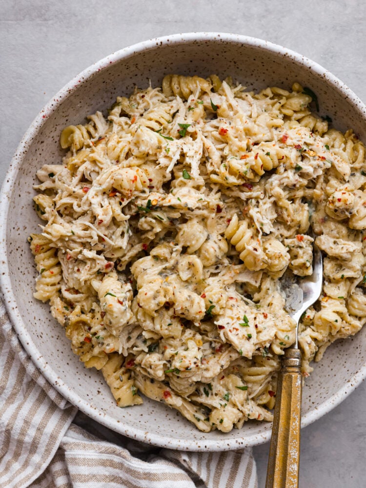 A serving of chicken pasta in a gray speckled bowl.