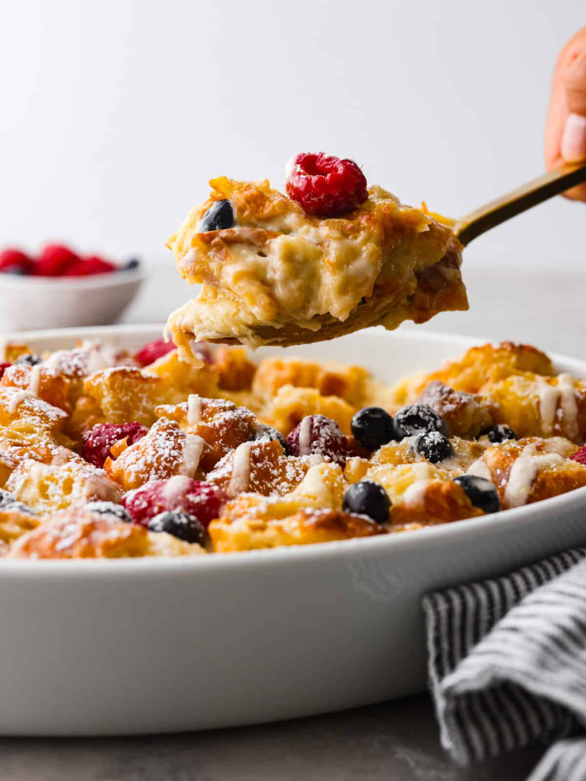 Serving a scoop of croissant breakfast casserole.