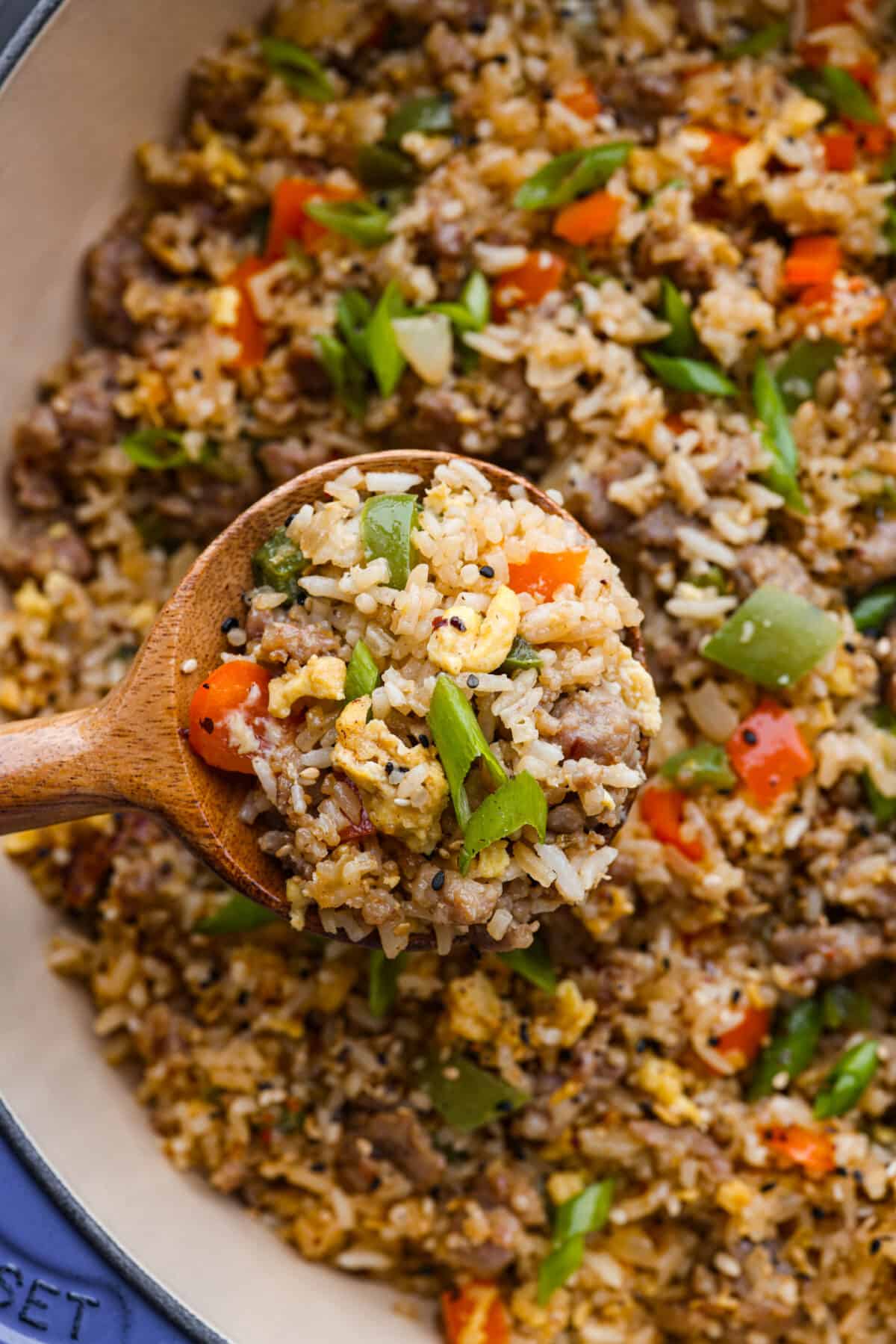 A closeup of a spoonful or fried rice on a wooden spoon. 