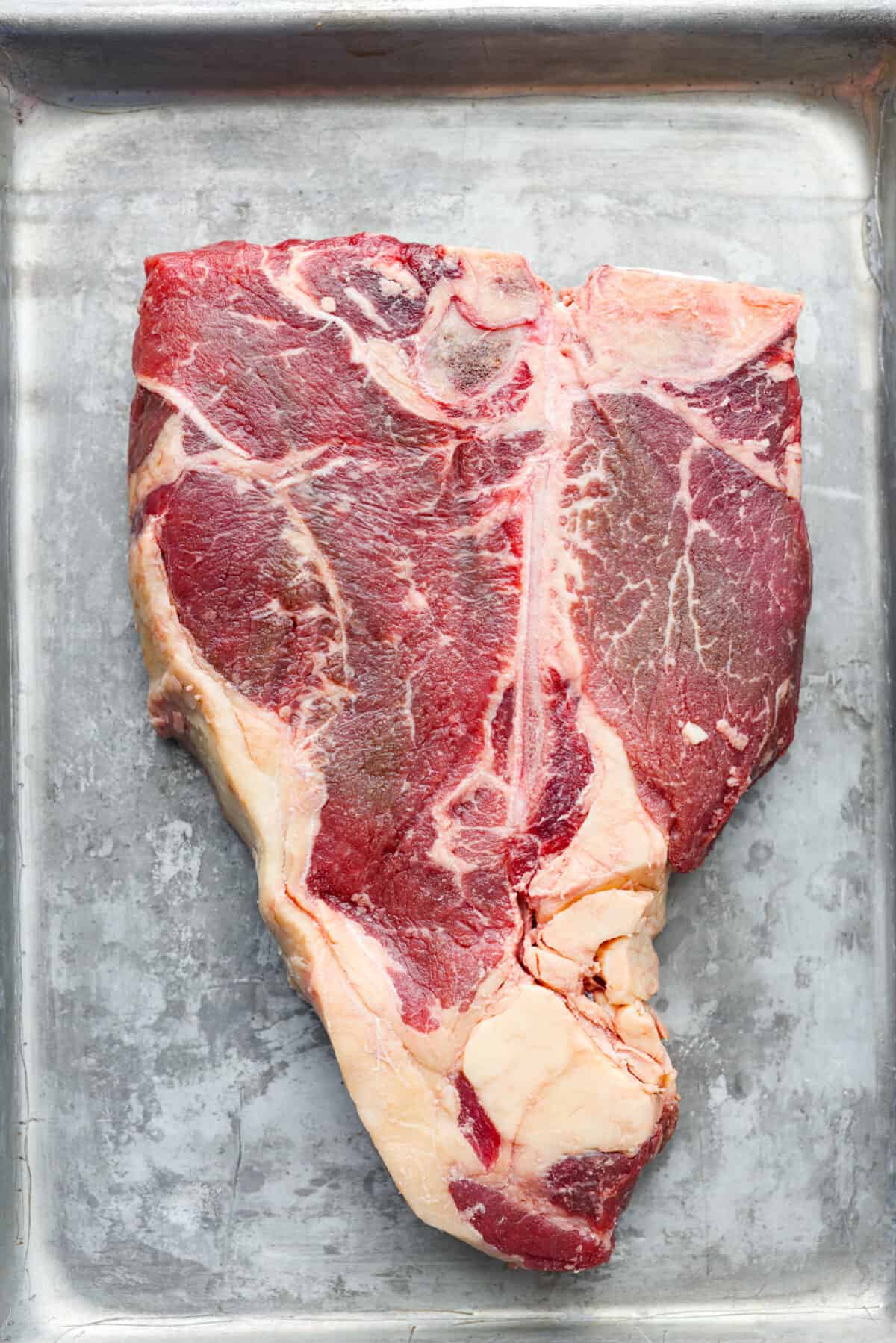 Top-down view of a raw tbone steak.