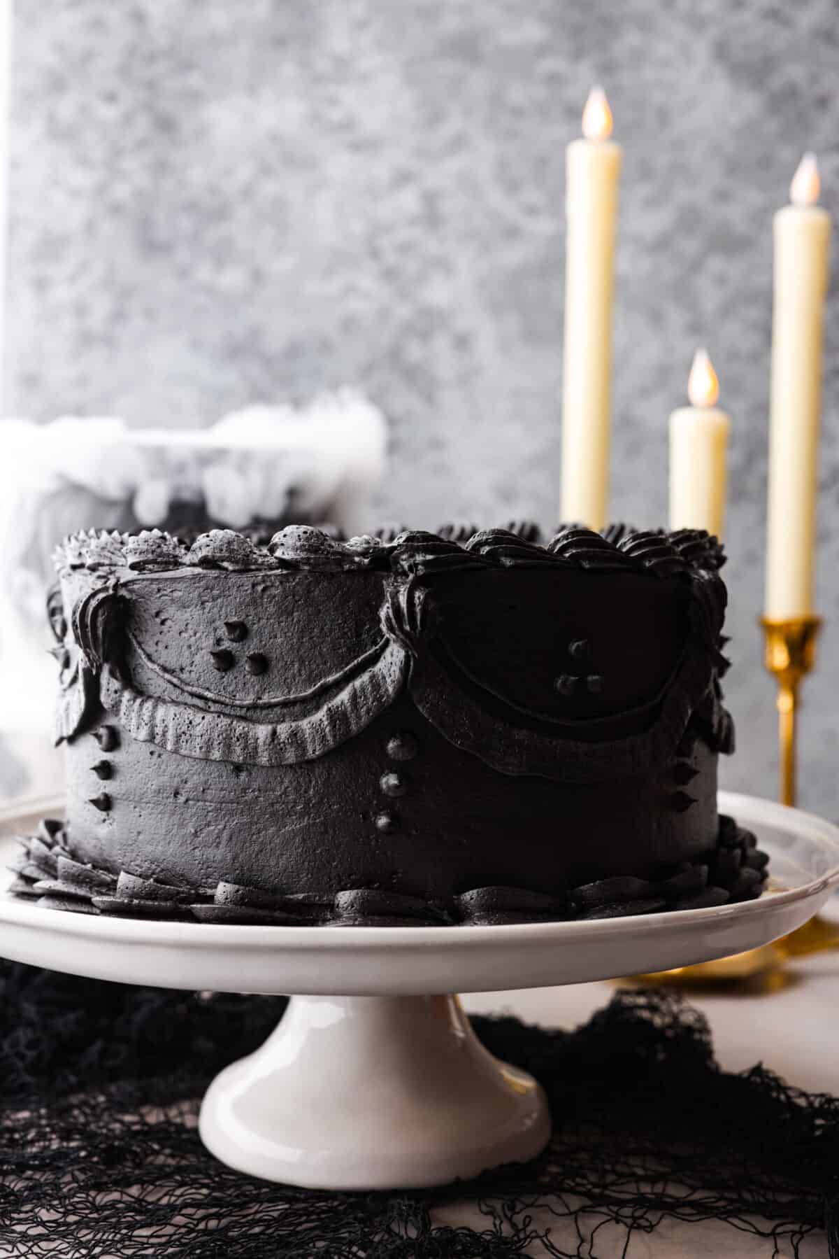 Hero image of a whole black velvet cake on a serving platter.