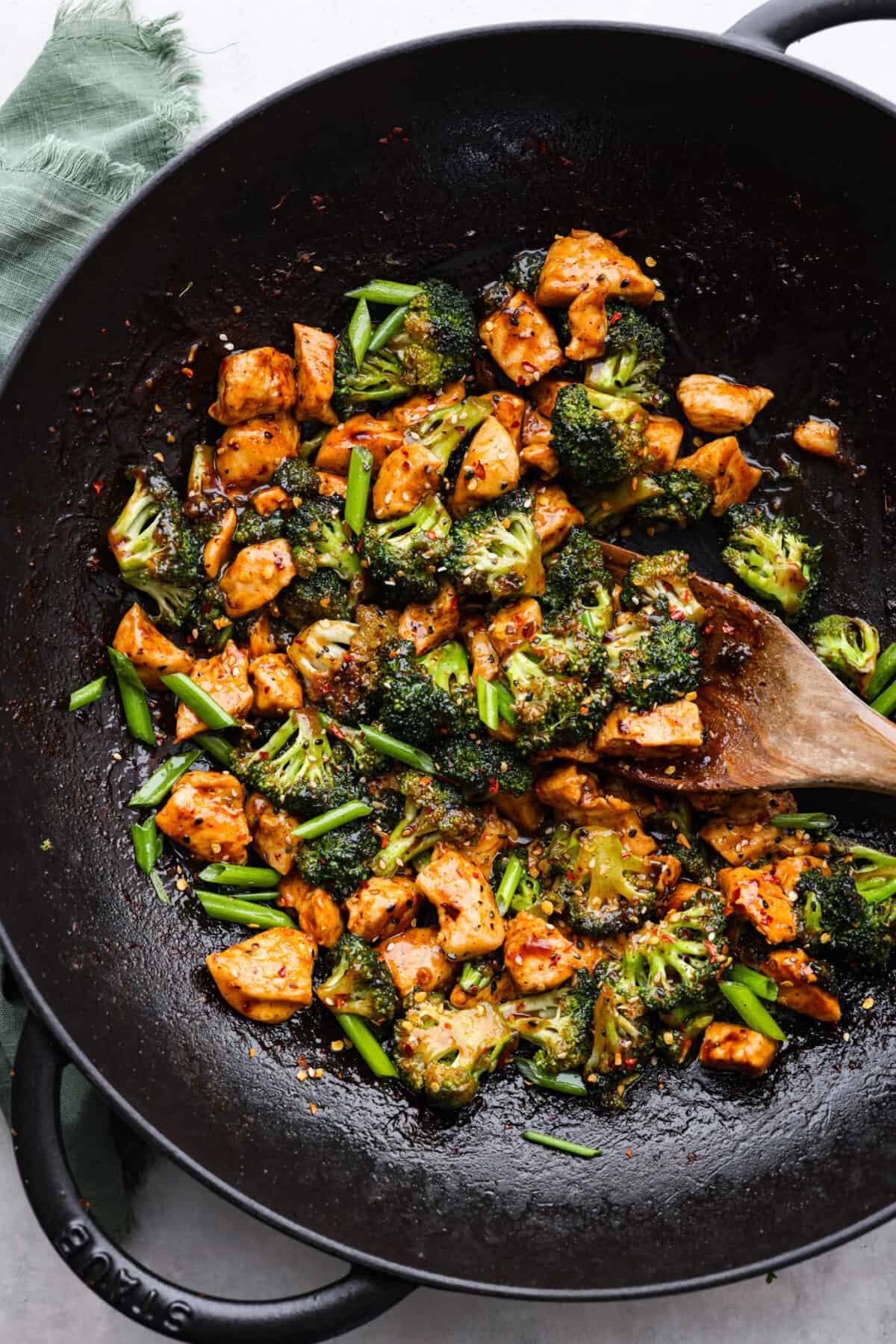Top-down view of Chinese chicken and broccoli being stir-fried in a wok.