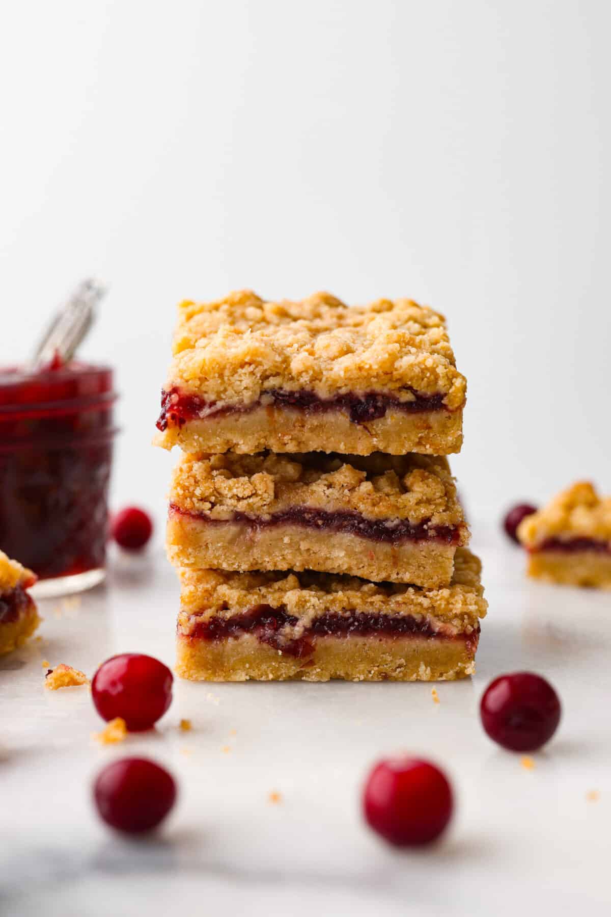 3 cranberry bars stacked on top of each other.
