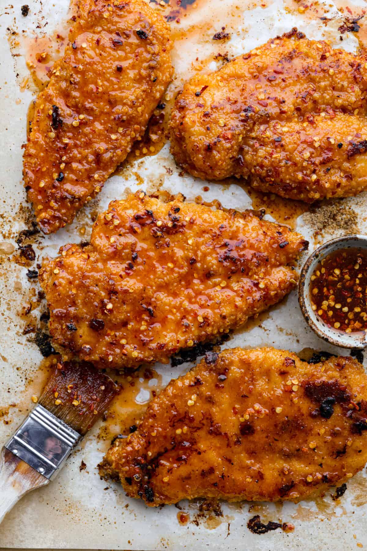 Top-down view of hot honey chicken on a baking sheet.