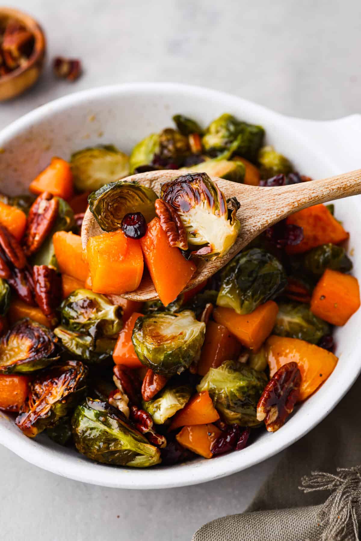Maple roasted brussels sprouts and butternut squash in a wooden spoon.