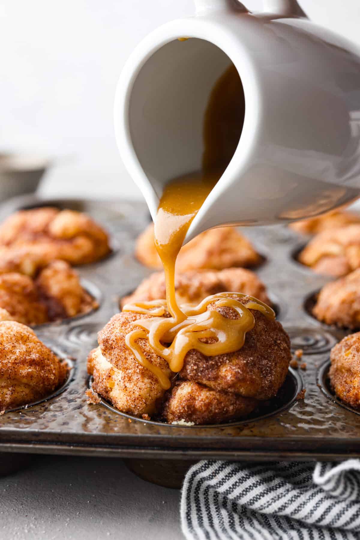 Pouring caramel sauce over a muffin.