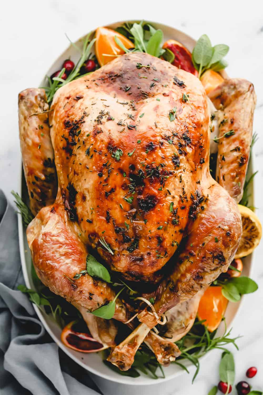 Oven baked herb turkey roasted and plated on a platter before being sliced,