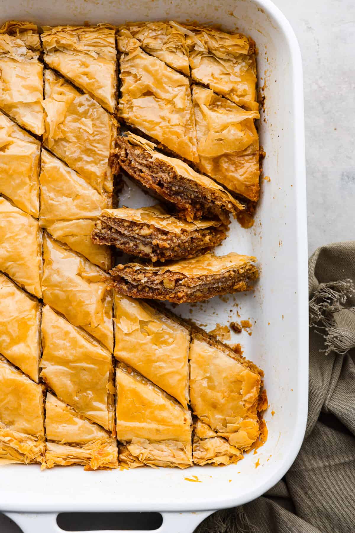 Baklava in a baking dish, cut into slices.