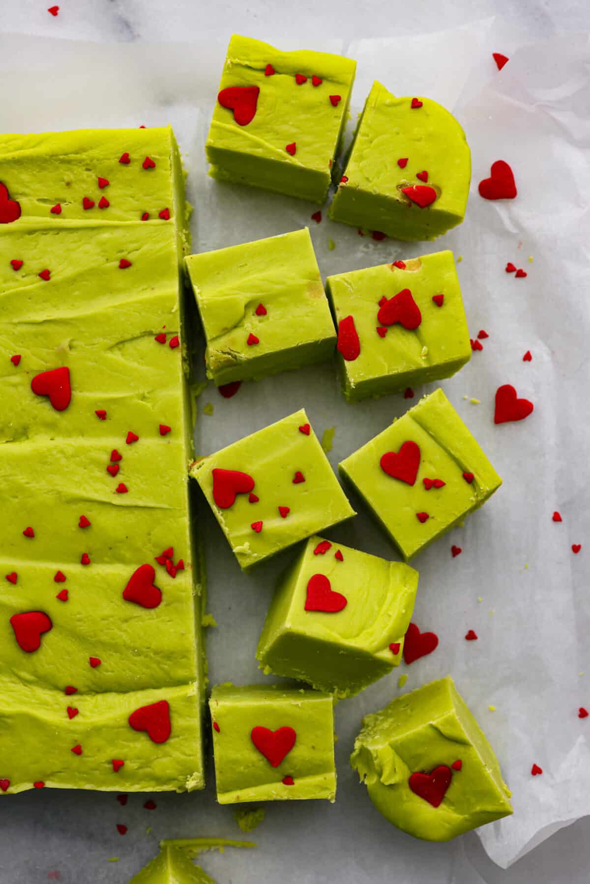 The top view of Grinch fudge on parchment paper cut into cubes. 