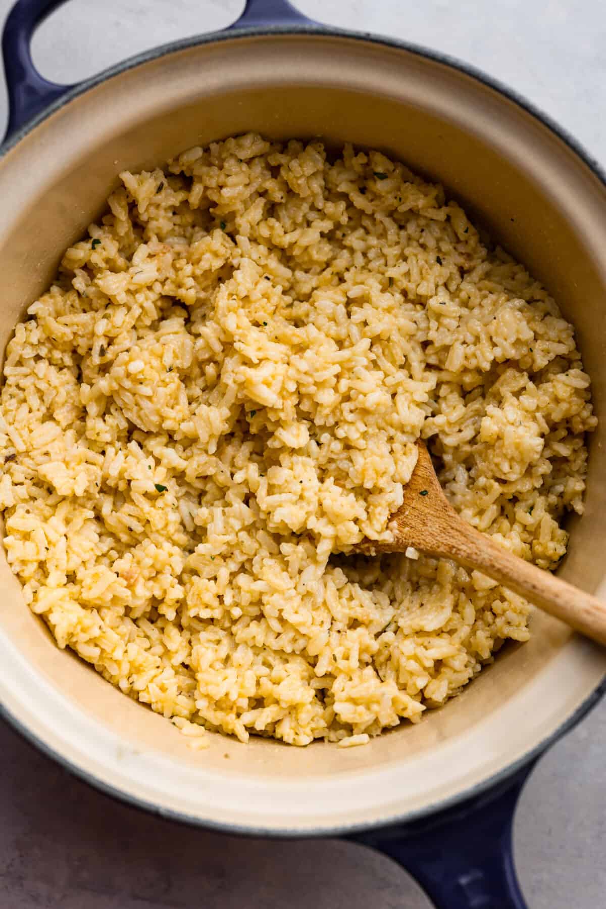 Souper rice cooked and ready to eat in a pot with a wooden spoon. 