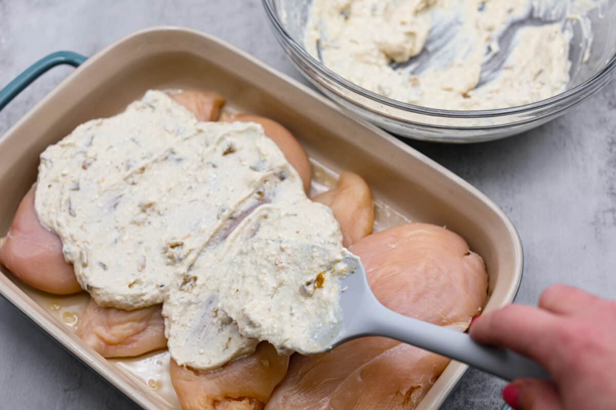 Adding the cream cheese mixture to the chicken breasts.