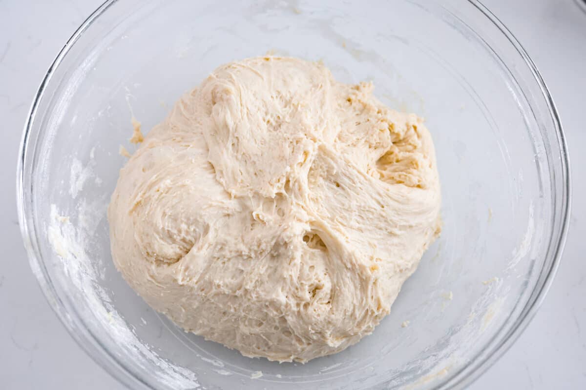 Third process photo of the mixed dough in a bowl before it rises.