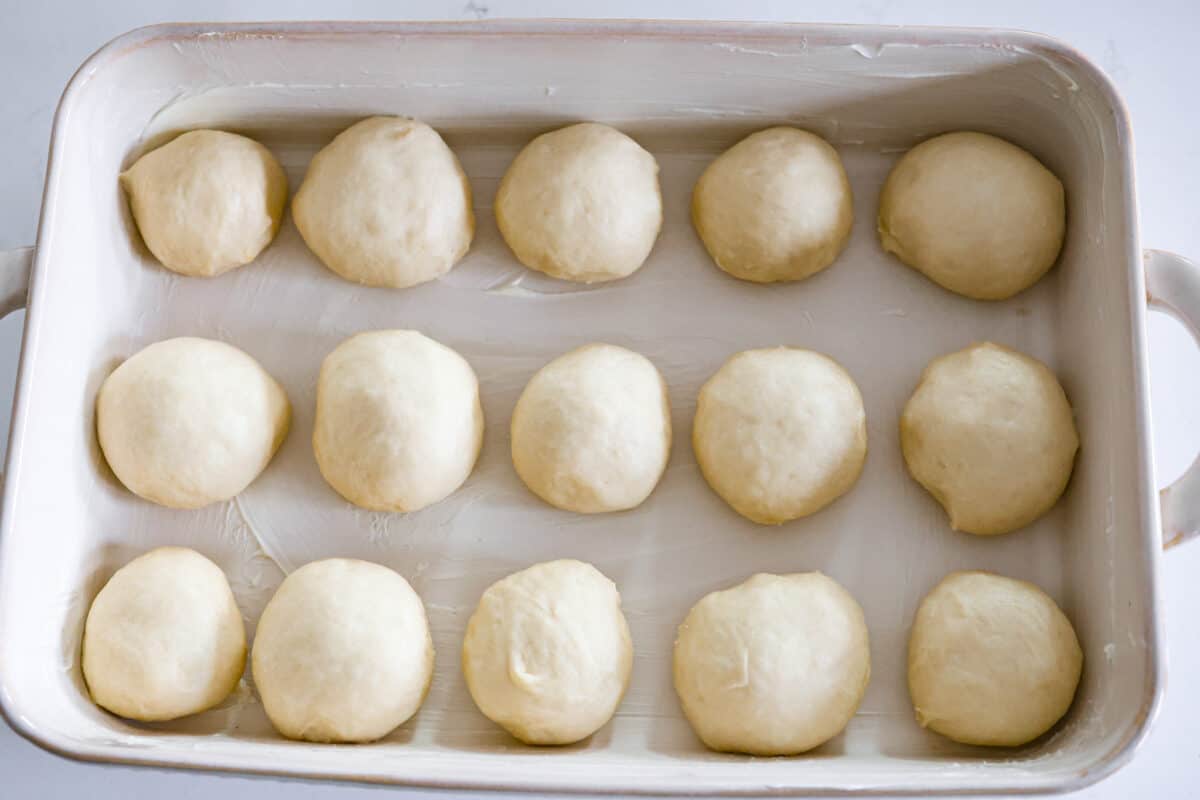 Sixth process photo of the dough shaped into rolls and placed in a pan.