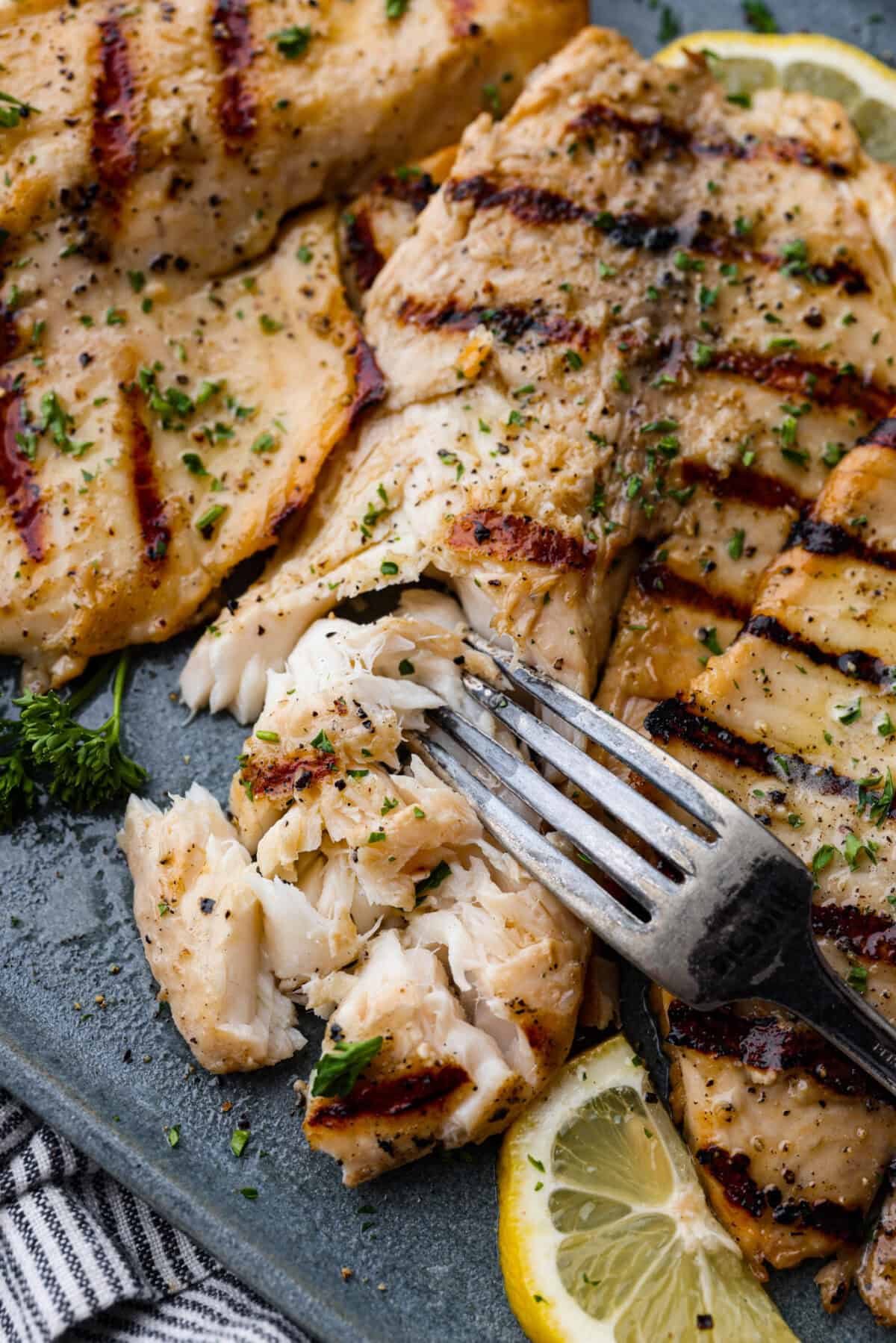 Close of of tilapia on a plate with a fork. 