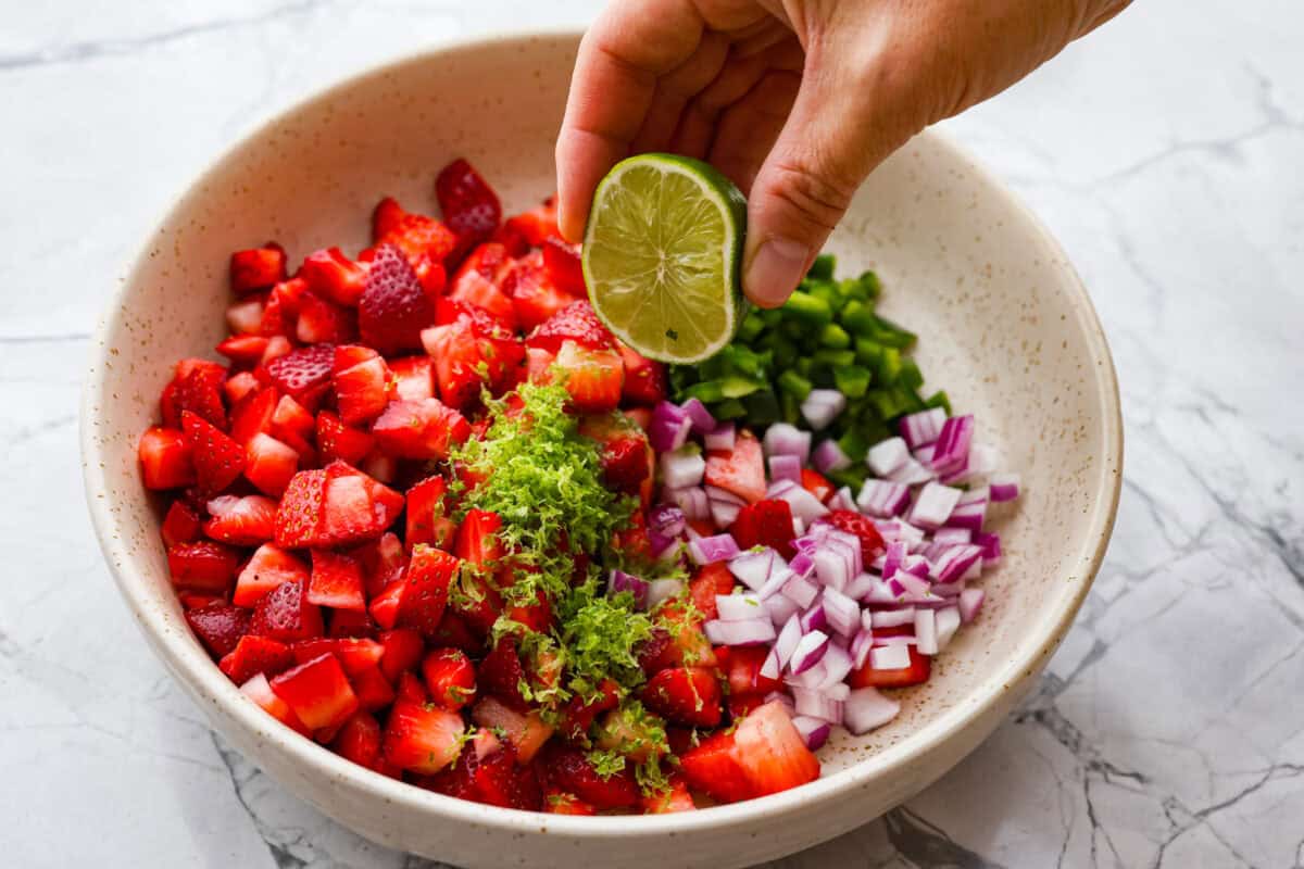 Lime being squeezed into the salsa. 