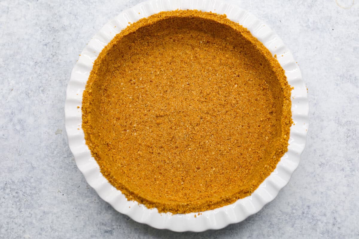 Overhead shot of graham cracker crumb crust in pie dish. 