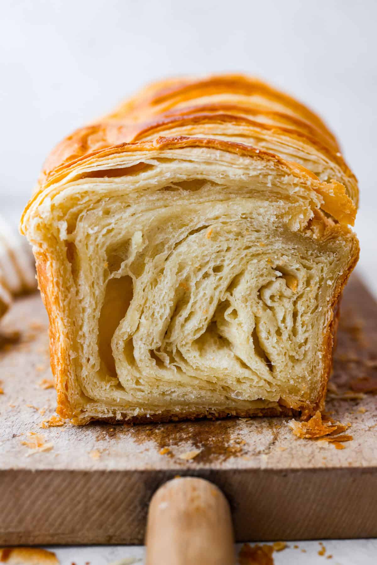 Side shot of croissant loaf sliced down the middle. 