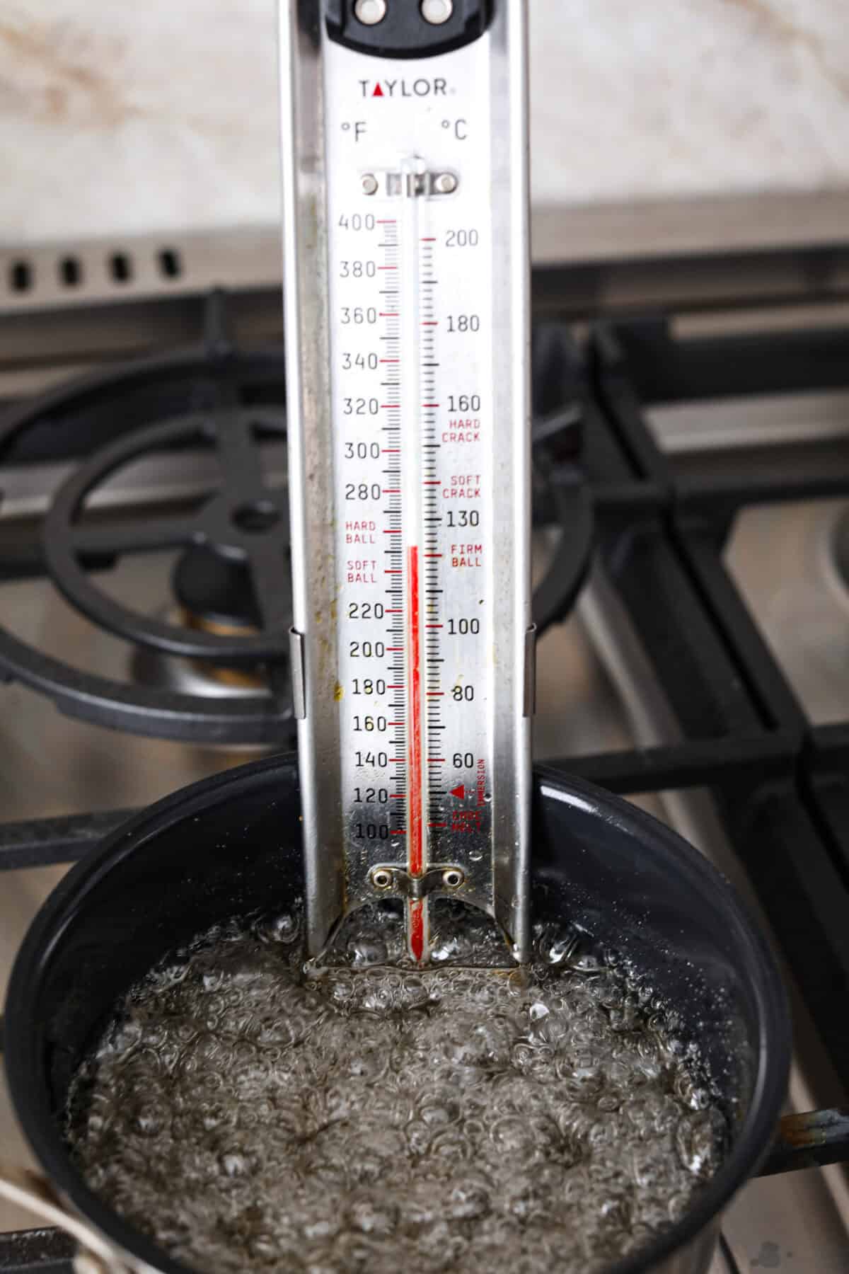 A candy thermometor reaching 240 degrees Fahrenheit. 