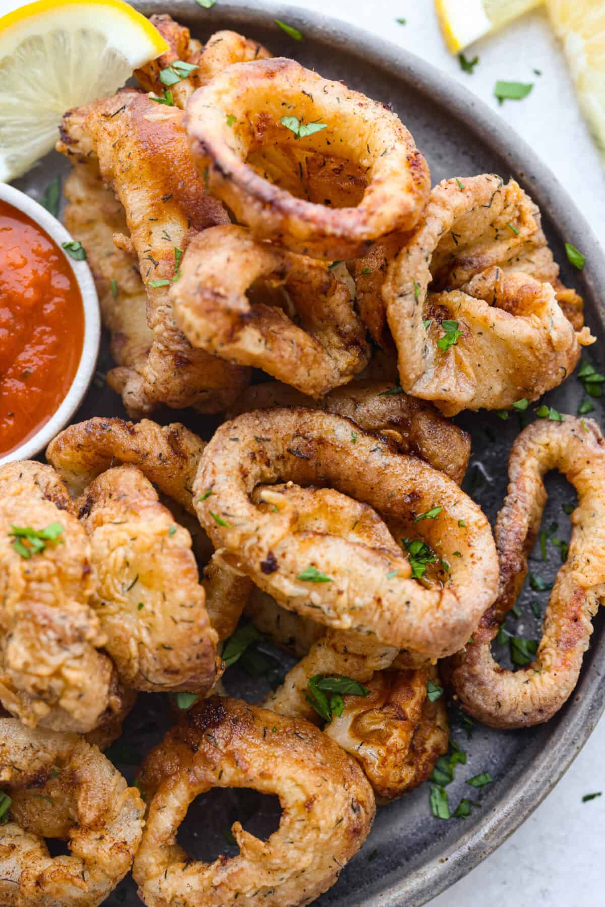 Overhead shot of plated calamari with marinara sauce on the side.