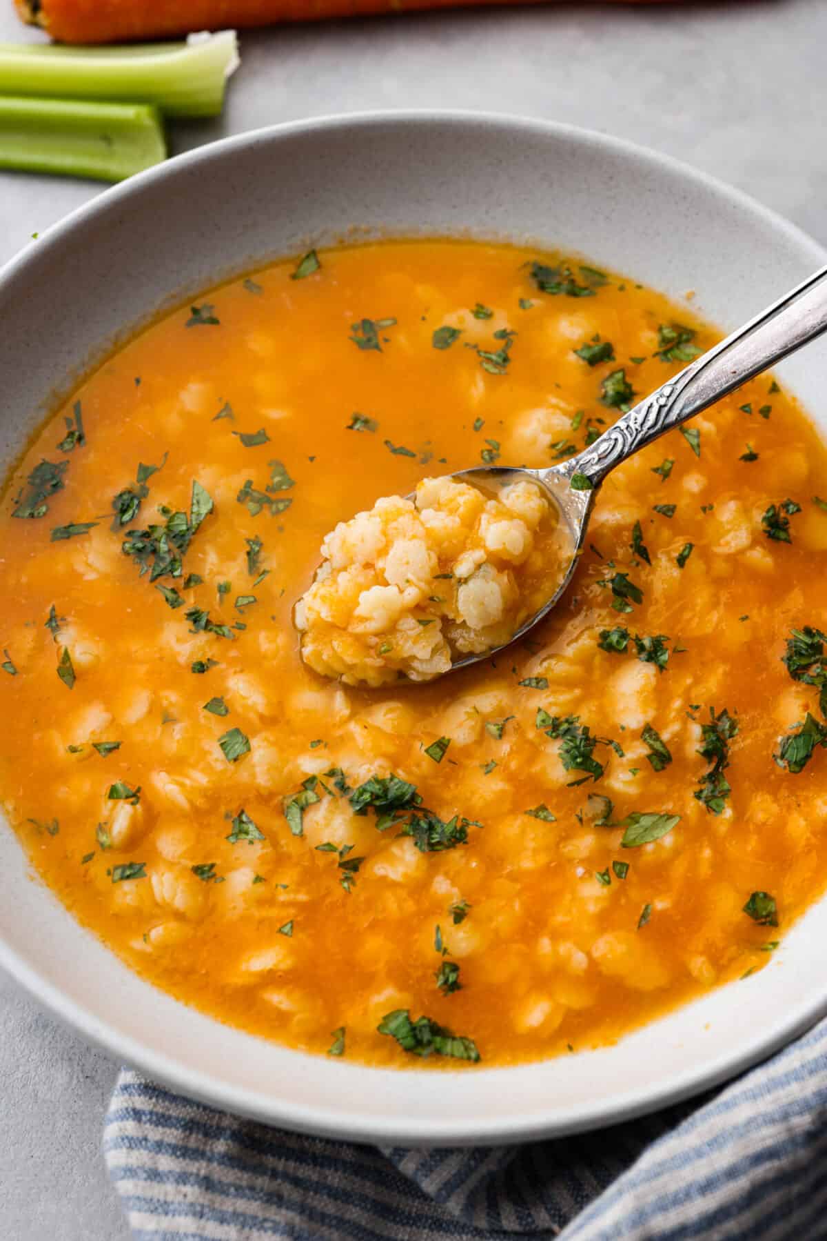 Warm and nourishing Italian Pastina is comfort food at its best! This simple soup recipe is made with chicken broth, vegetables and tiny pasta stars. It's the perfect cozy meal to enjoy when the weather turns cold! A spoonful of pastina in a metal spoon.