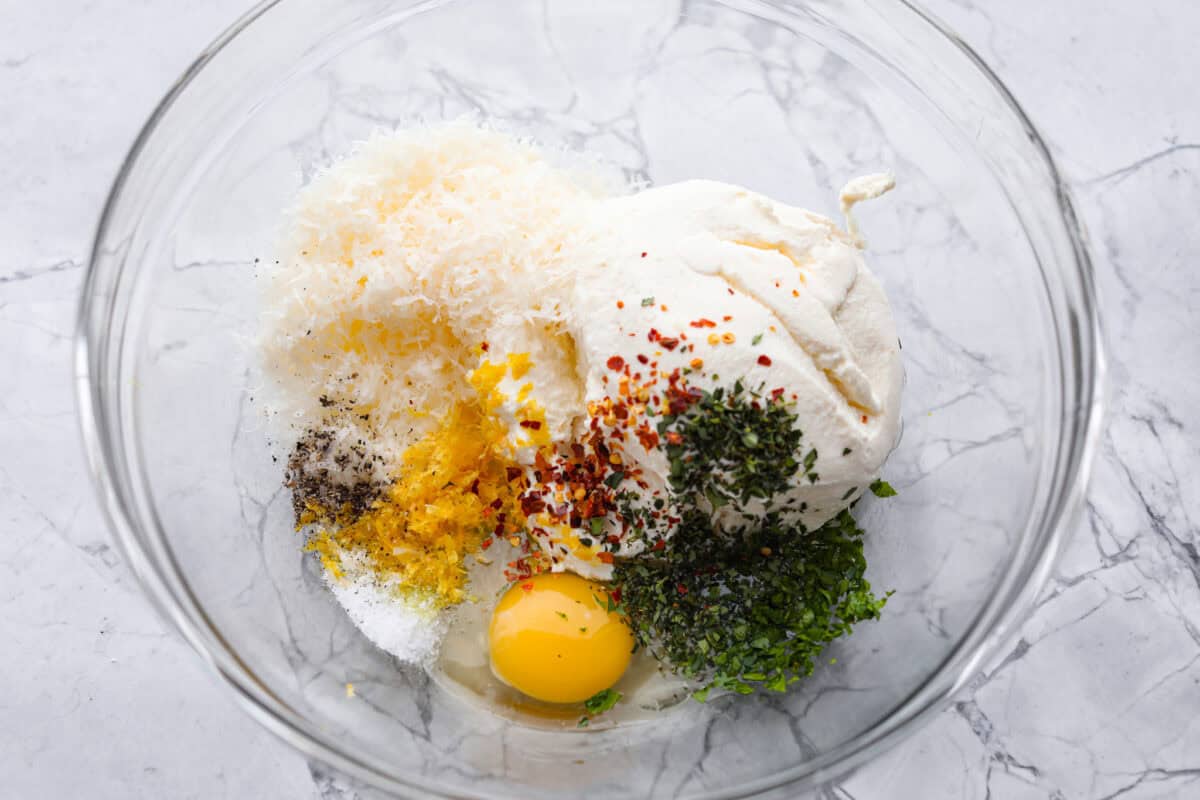 Overhead shot of dip ingredients in a glass bowl. 