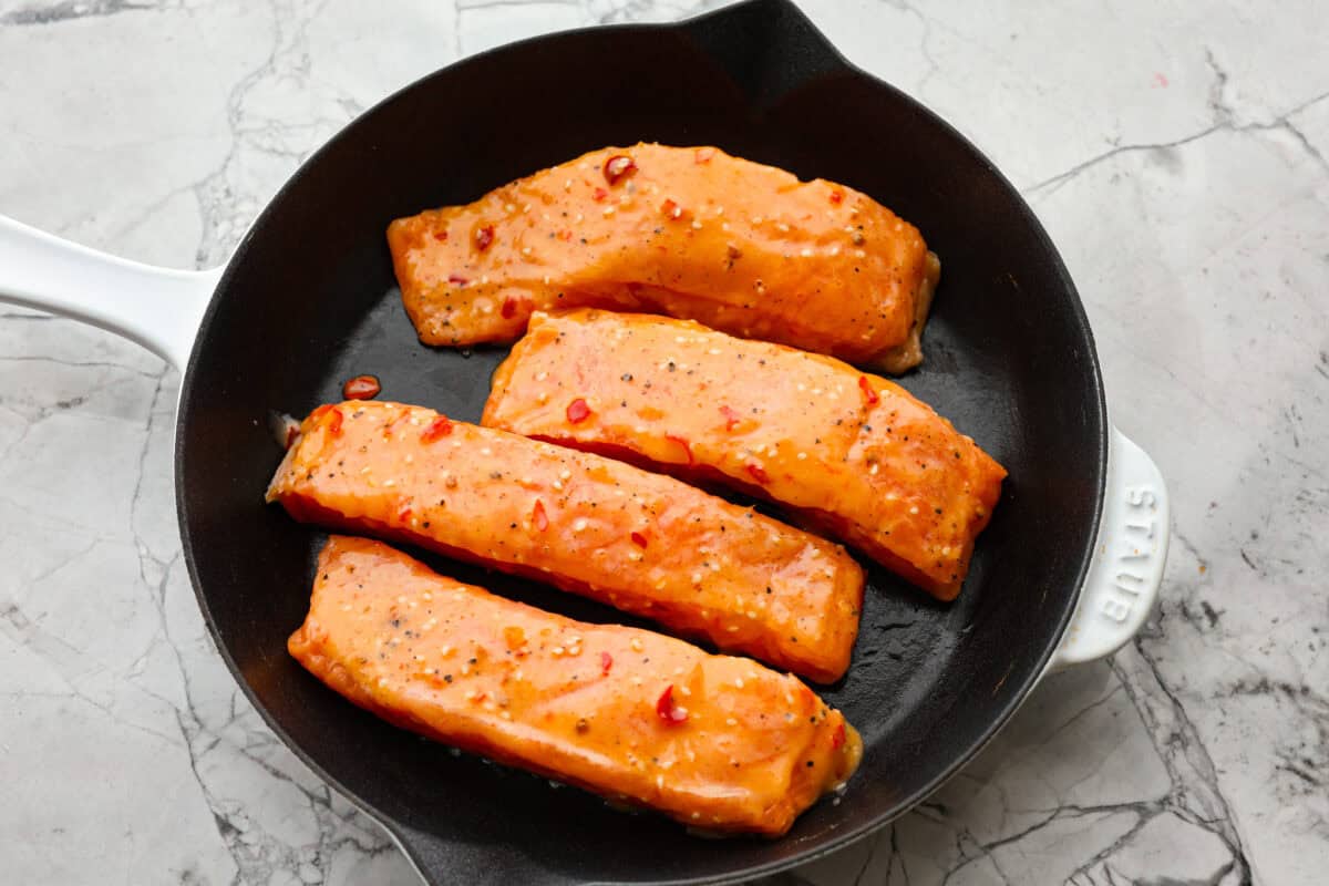 Overhead shot of salmon filets in a skillet. 