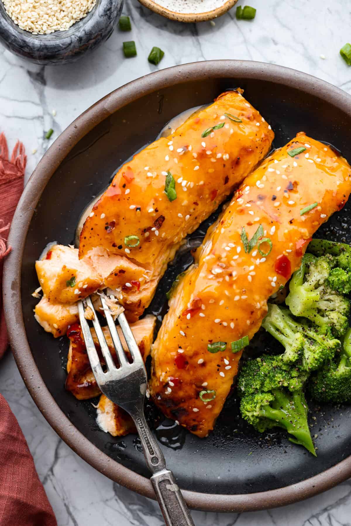 Overhead shot of plated bang bang salmon next to broccoli. 