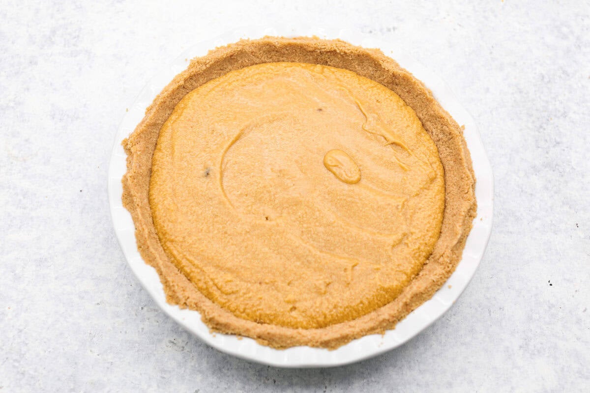 Overhead shot of crack pie filling in the oatmeal crumb crust in a pie pan. 