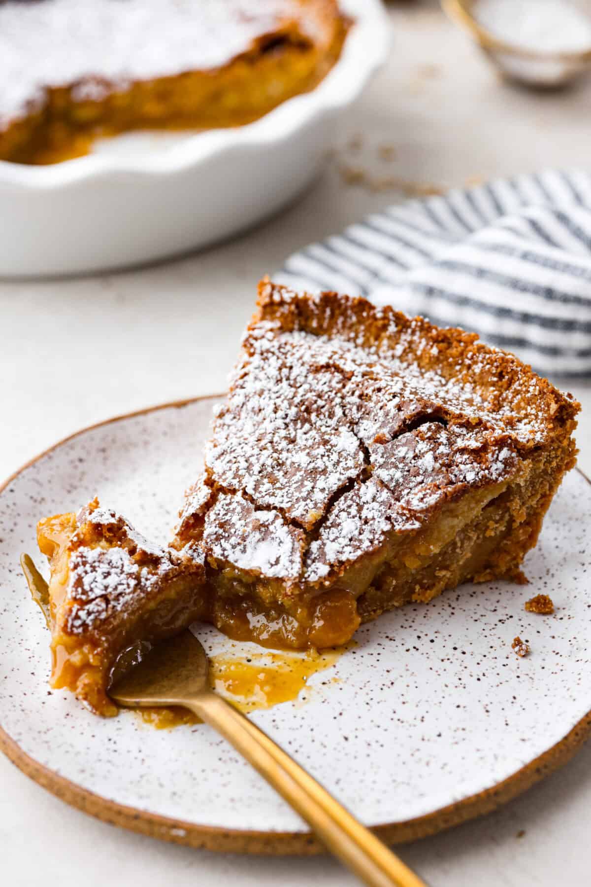 Angle shot of a slice of crack pie with a bite on a fork. 