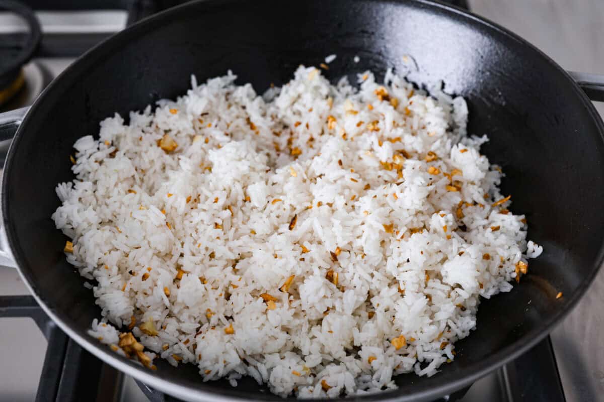 Angle shot of rice added to the pan. 