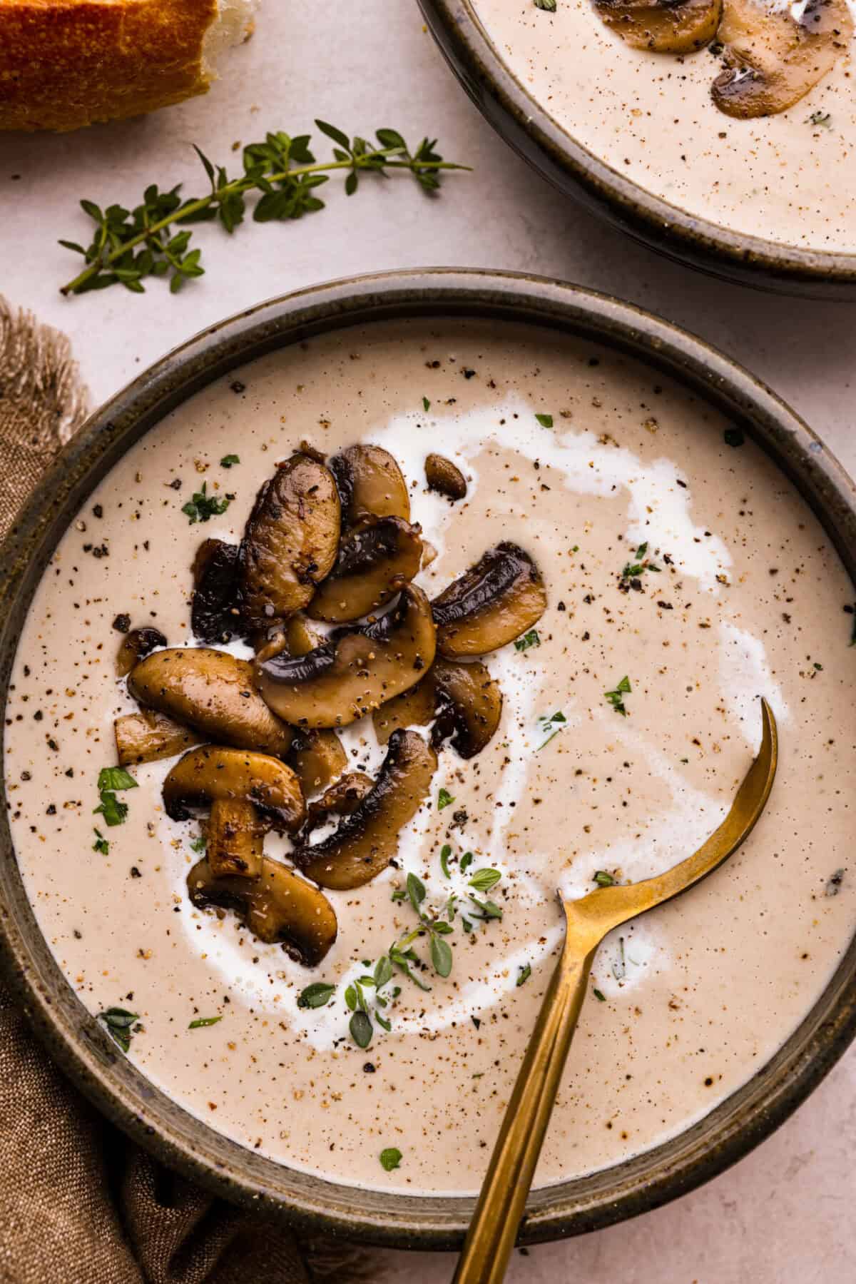 Overhead shot of a bowl of mushroom bisque with sautéed mushrooms on top. 