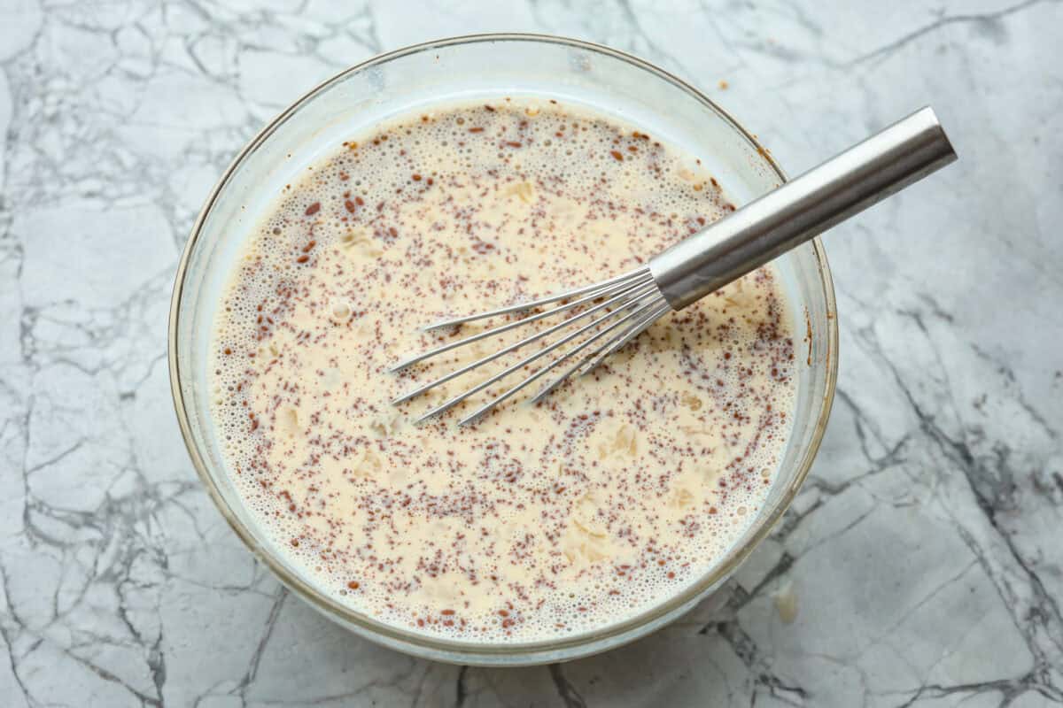 Overhead shot of custard ingredients whisked together in a bowl. 